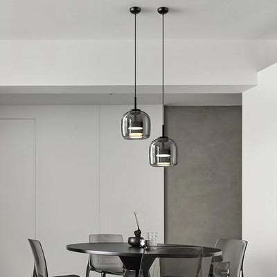 Minimalist black and glass pendant light fixtures hanging over a modern dining table in a contemporary space.